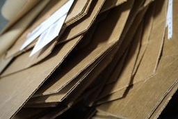 ISRI found that 80 percent of paper produced by U.S. mills is made from recovered paper, using 68 percent less energy and reducing carbon dioxide emissions by 47 percent compared to making paper from virgin material. Cardboard boxes stacked for recycling.
