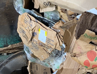 Bottles, cans and plastic wrap. Plastic milk crates. Even an office chair and a toilet seat. Cardboard contamination is not new, but it’s a much more expensive problem than it was before as can be seen in these photos.