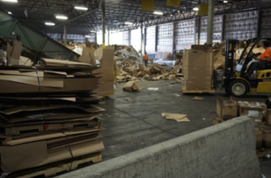 Companies that implement an efficient recycling process save time and money. Warehouse of organized recycled materials.