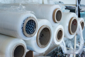 Rolls of plastic film on a shelf to be used in commercial packaging.