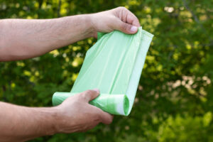 A man unrolls some green Biodegradable plastics.